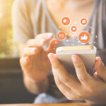 TV al fondo con un móvil en primer plano