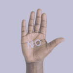 Mano delante de fondo violeta con un NO escrito en su palma